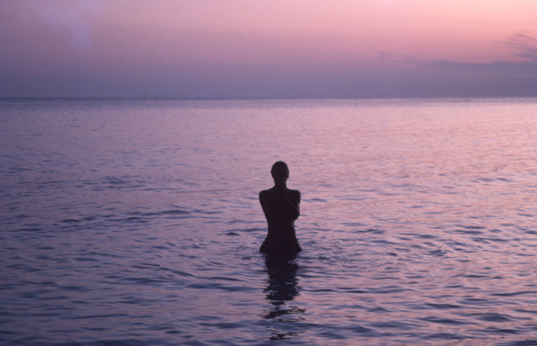 photo of woman standing in the calm Bahamas water